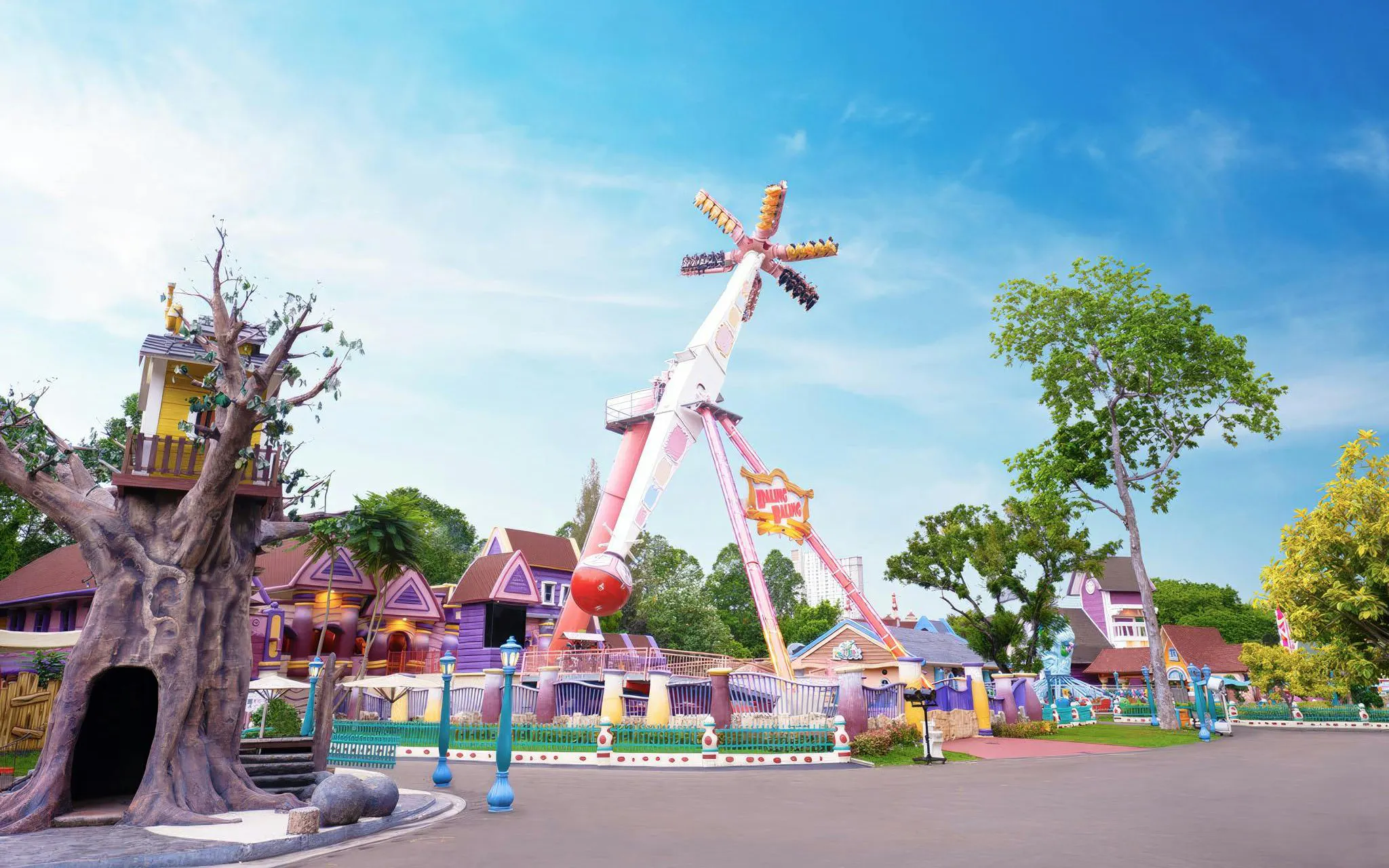 Baling-Baling ride at Dunia Fantasi in Jakarta, Indonesia, with colorful buildings and trees.