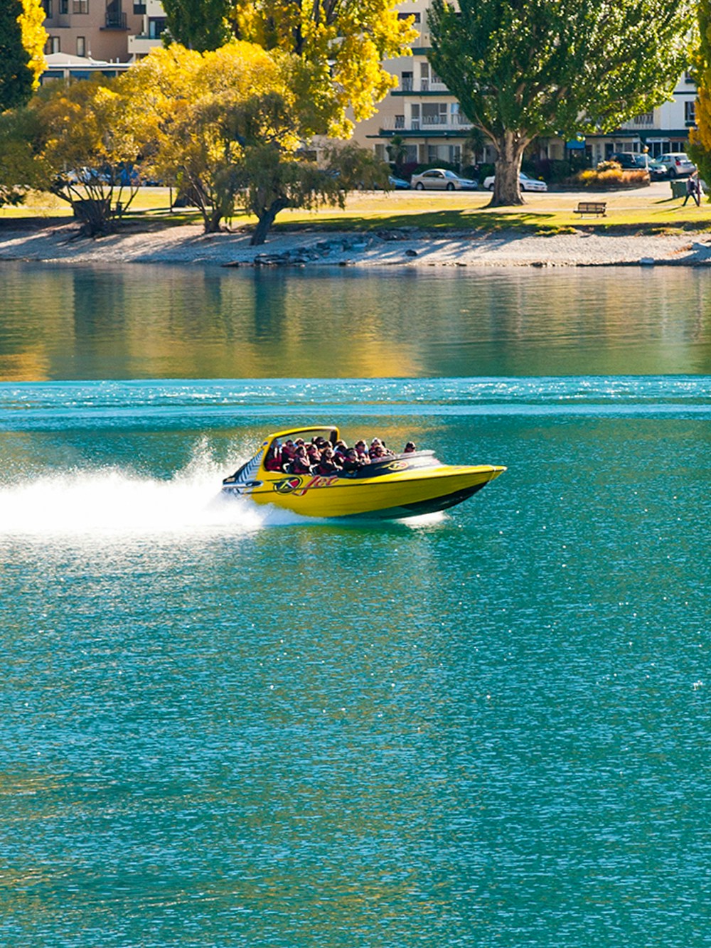 Jet boat speeding through Shotover River canyon in Queenstown, New Zealand.