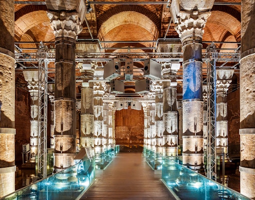 Illuminated columns inside Theodosius Cistern, Istanbul, showcasing ancient architecture.