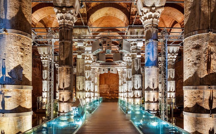 Illuminated columns inside Theodosius Cistern, Istanbul, showcasing ancient architecture.