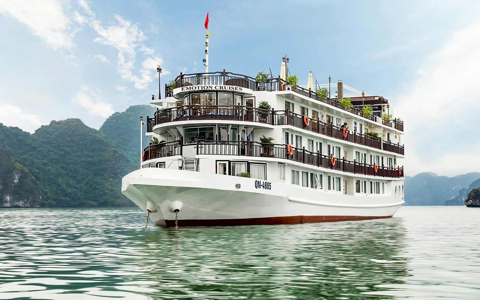 Emotion Cruise ship on Halong Bay with limestone karsts in the background.