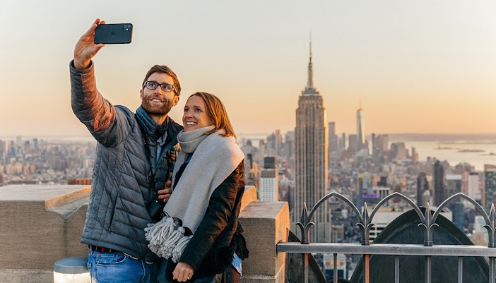 Couple taking selfie with Empire State Building in background at Top of the Rock, Rockefeller Center, New York.