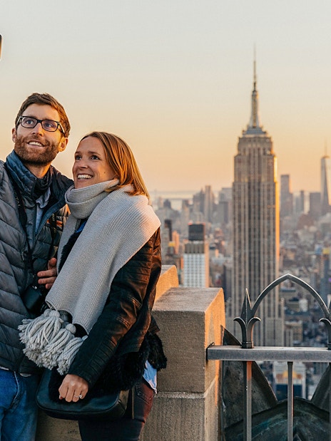 Couple taking a selfie with Empire State Building from Top of the Rock, New York City.
