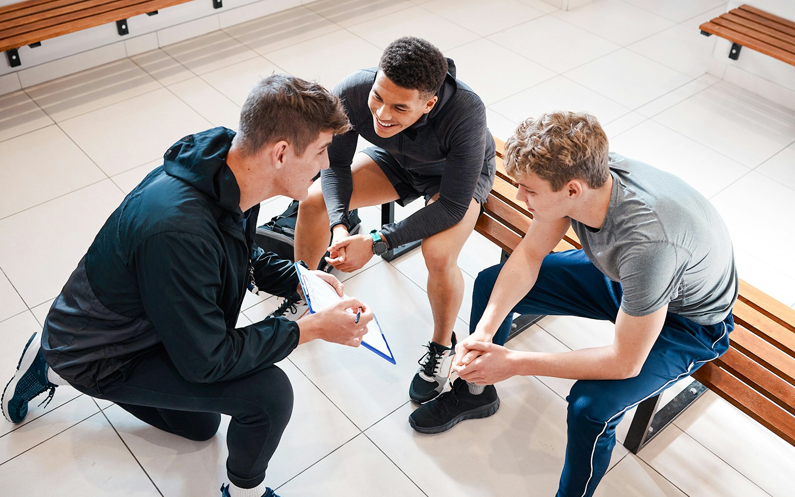 Tennis players discussing strategy in Roland Garros Stadium locker room.