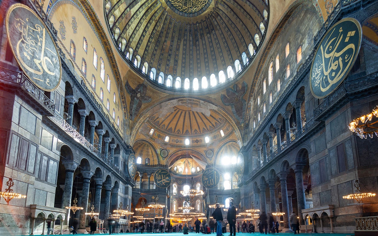Hagia Sophia interior with visitors on a historian-guided tour in Spanish, Istanbul.