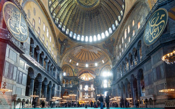 Hagia Sophia interior with visitors on a historian-guided tour in Spanish, Istanbul.