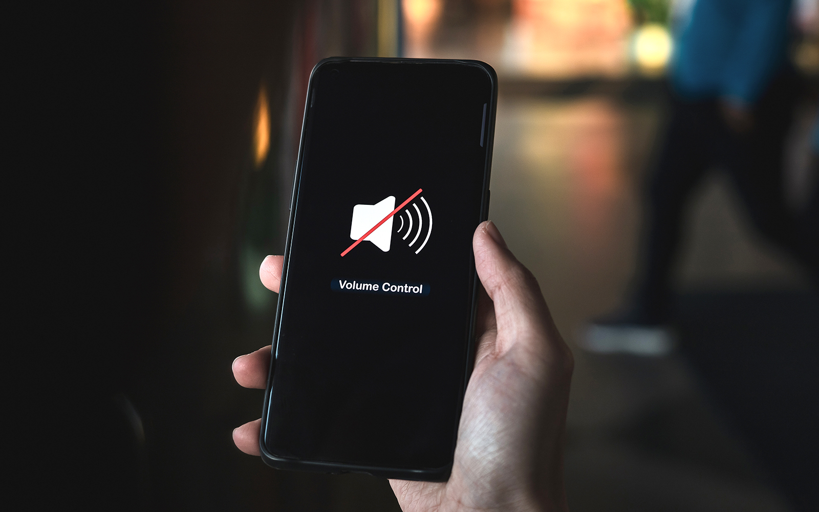 Hand pressing volume of the smartphone in silent or mute mode activated.