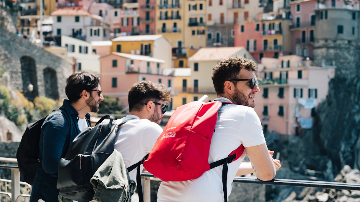 Tourists enjoying the view of colorful buildings in Cinque Terre, Italy.