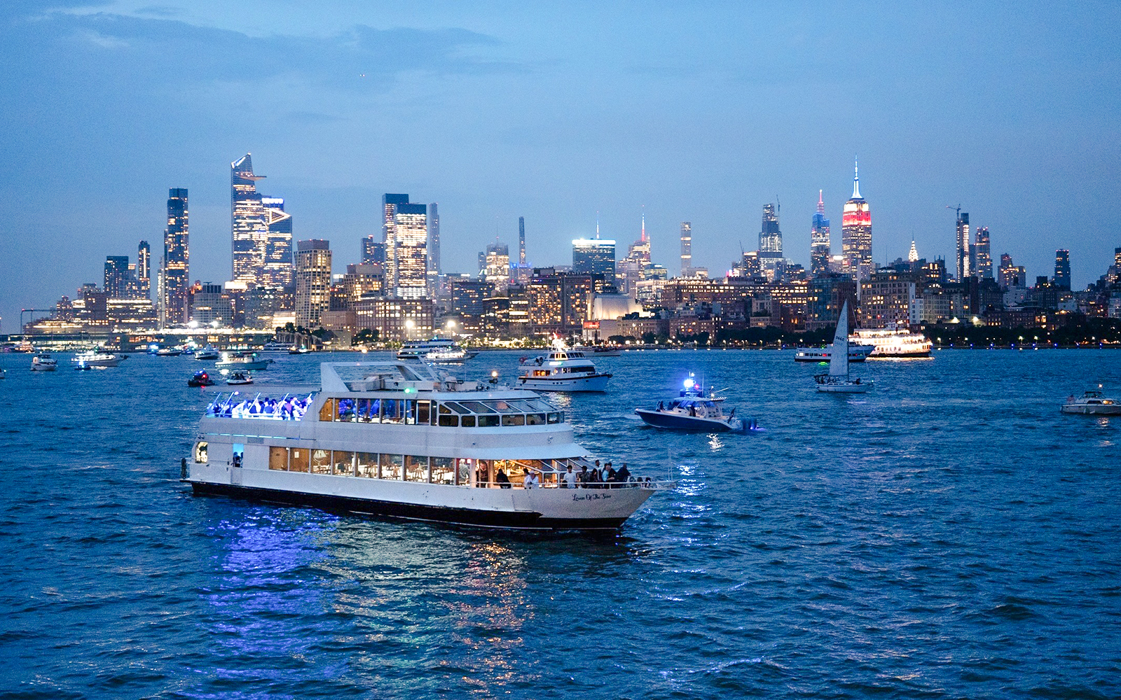 Cruise ship on New York City waters with skyline view during New Year's Eve.