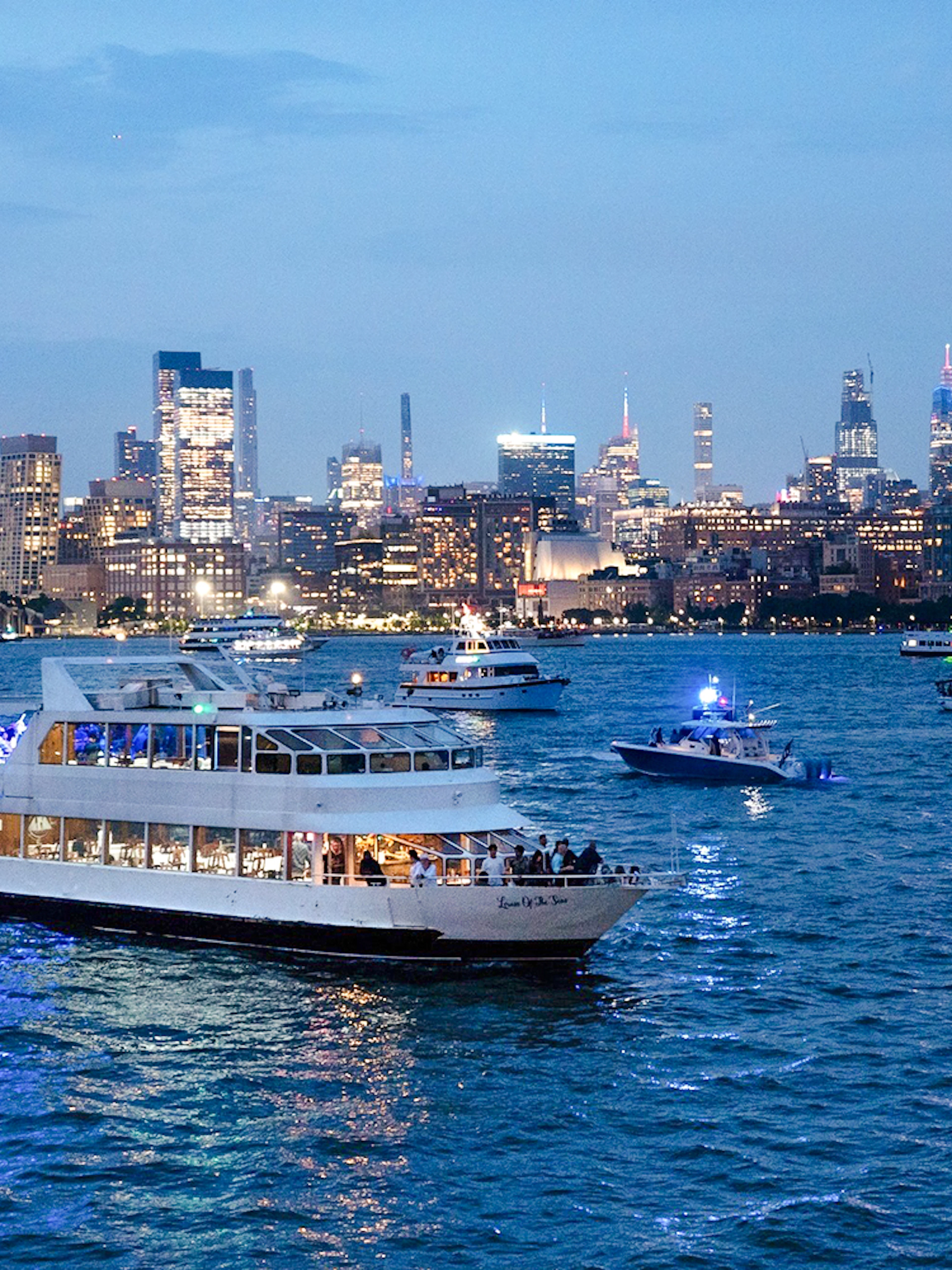 Cruise ship on New York City waters with skyline view during New Year's Eve.