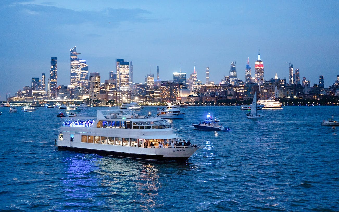 Cruise ship on New York City waters with skyline view during New Year's Eve.