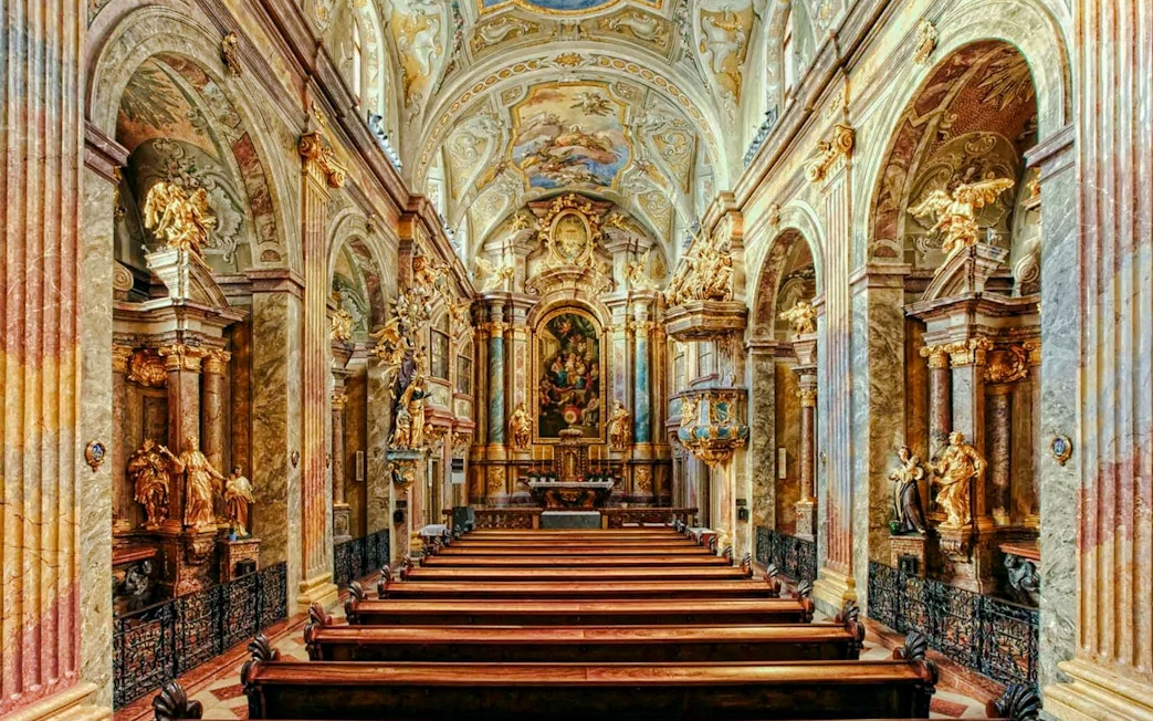 Interior of St Anne's Church with ornate arches and detailed frescoes.