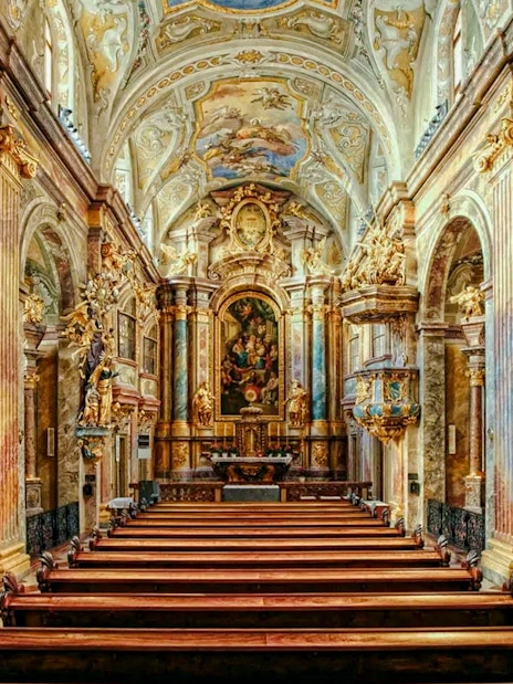 Interior of St Anne's Church with ornate arches and detailed frescoes.