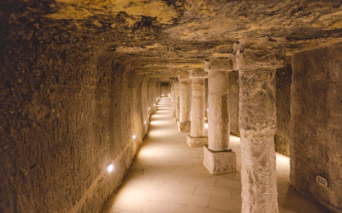 Ancient stone columns and brick walls inside the Step Pyramid of Djoser, Saqqara, Egypt.