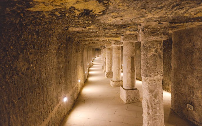 Ancient stone columns and brick walls inside the Step Pyramid of Djoser, Saqqara, Egypt.