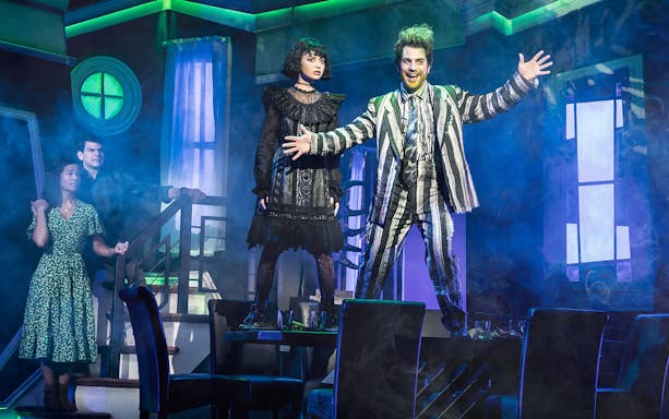 Stage scene from Beetlejuice West End with characters in dramatic poses.