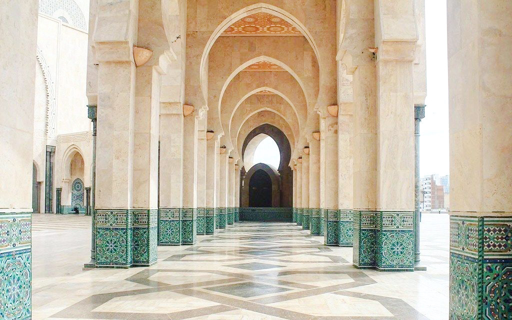 Interior arcade of Hassan II Mosque with ornate columns in Casablanca, Morocco.