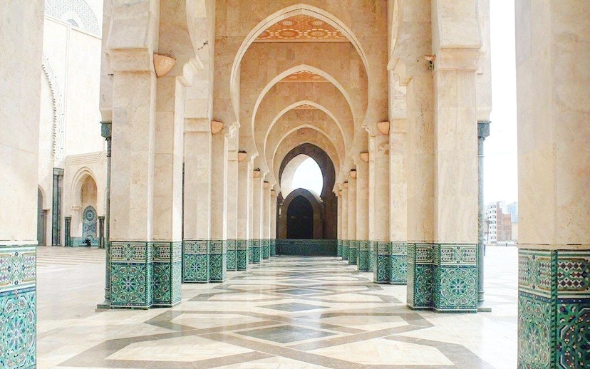 Interior arcade of Hassan II Mosque with ornate columns in Casablanca, Morocco.