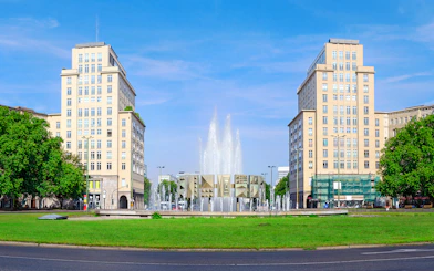 Berlin Karl-Marx-Allee with twin buildings and fountain on City Circle Hop-On Hop-Off Tour.