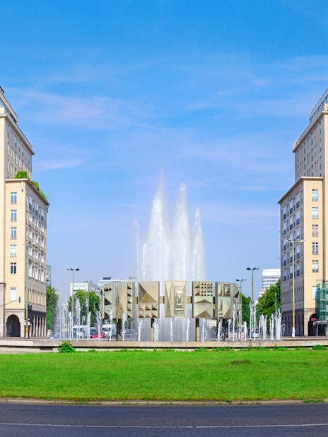 Berlin Karl-Marx-Allee with twin buildings and fountain on City Circle Hop-On Hop-Off Tour.