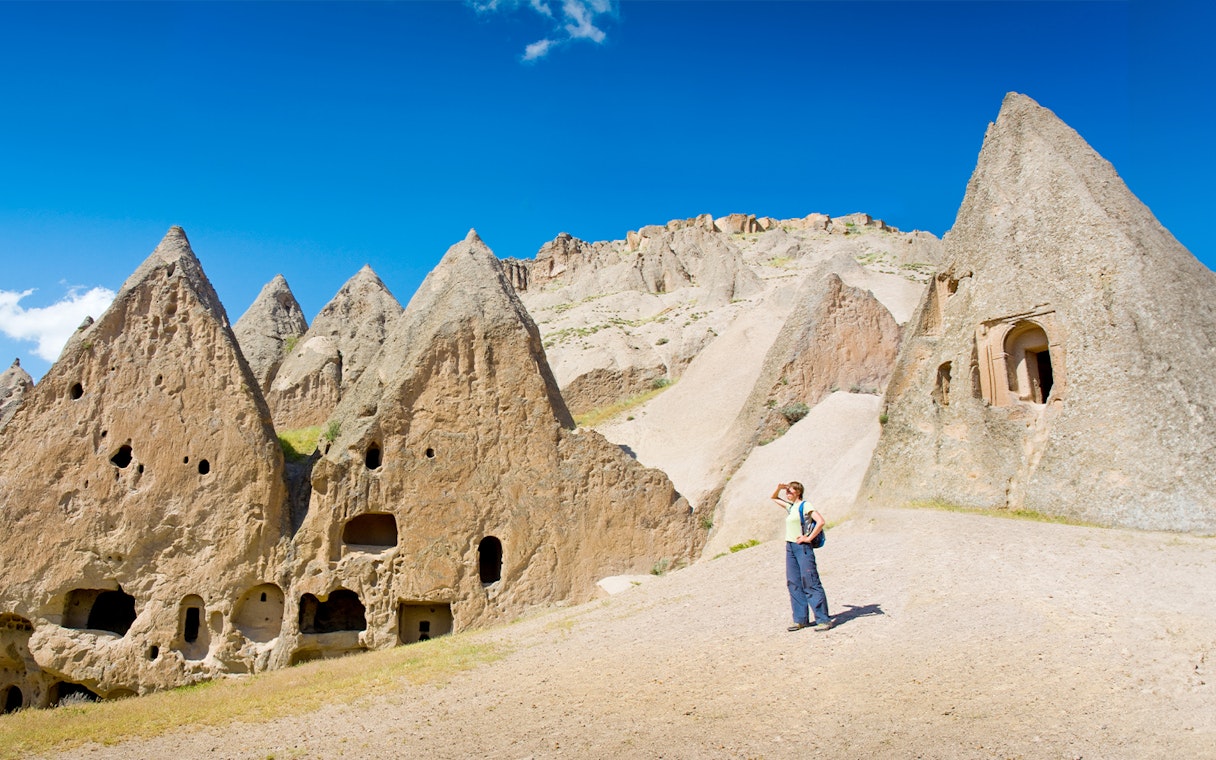 Trekker exploring rock formations in Cappadocia during the Full-Day Green Tour.