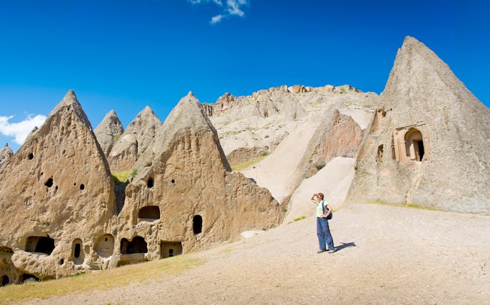 Trekker exploring rock formations in Cappadocia during the Full-Day Green Tour.