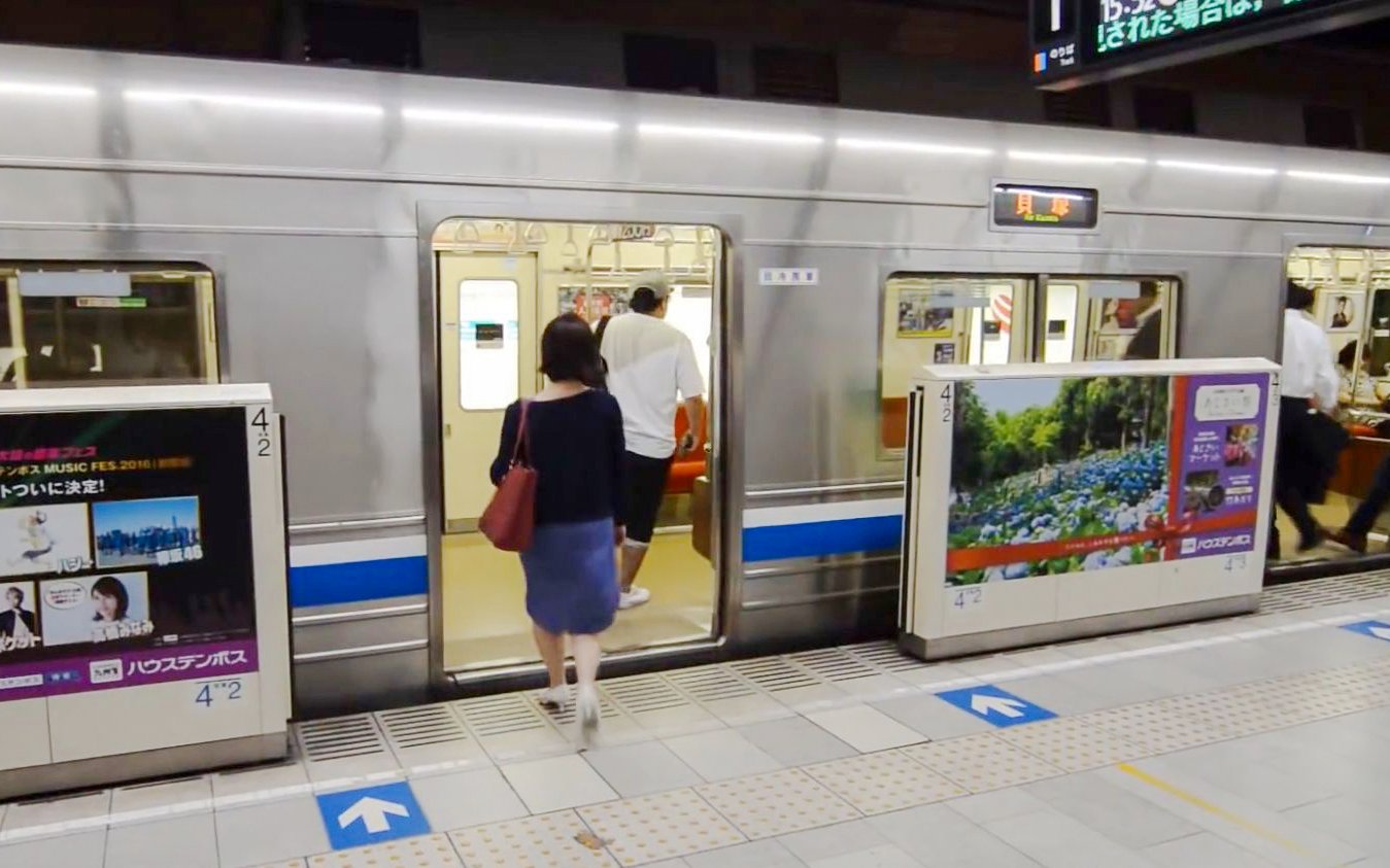 Passengers boarding a subway train in Fukuoka City station.