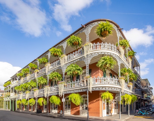 Historic building with wrought iron balconies and greenery in the French Quarter, New Orleans.