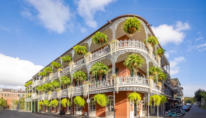 Historic building with wrought iron balconies and greenery in the French Quarter, New Orleans.