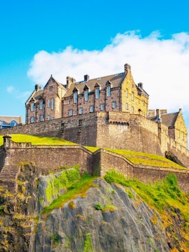 Edinburgh Castle on Castle Rock, Scotland, under a clear blue sky.