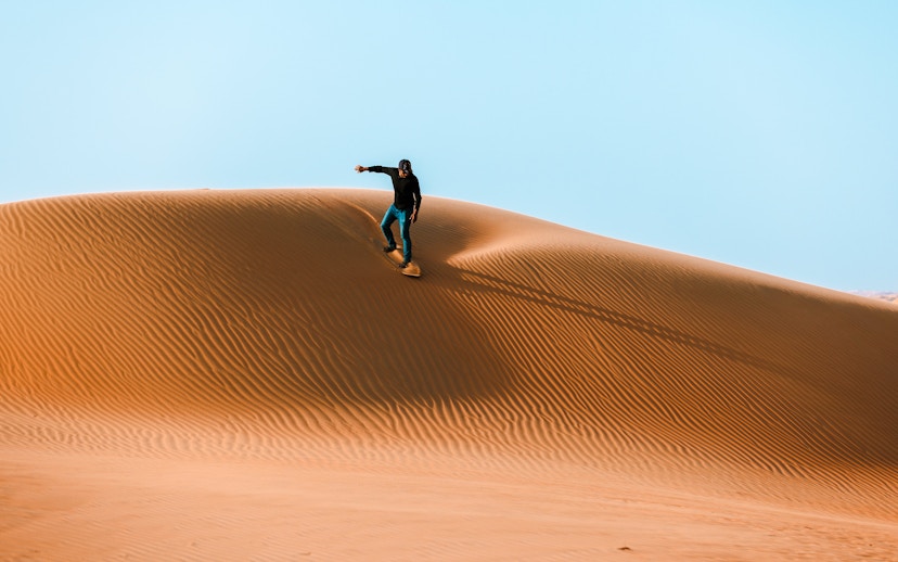 Sandboarding on a dune in Doha desert, Qatar.