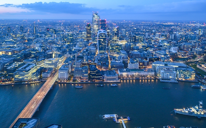 London skyline from The Shard at dusk, featuring illuminated cityscape and Thames River.