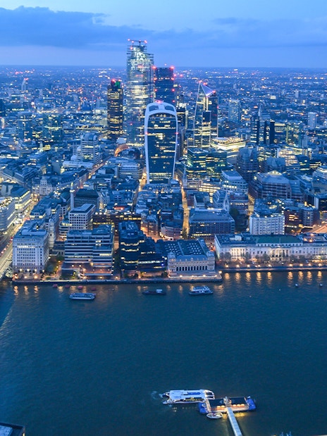 London skyline from The Shard at dusk, featuring illuminated cityscape and Thames River.