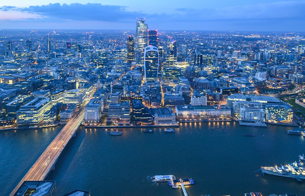 London skyline from The Shard at dusk, featuring illuminated cityscape and Thames River.