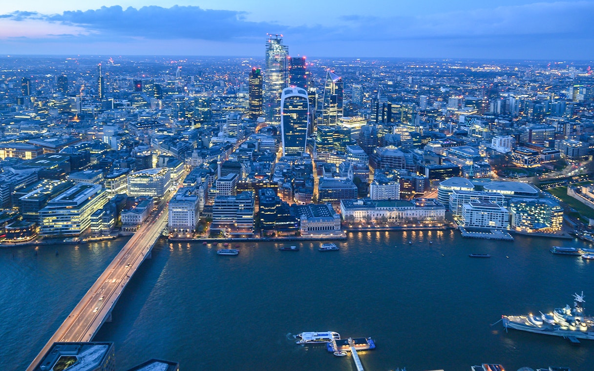 London skyline from The Shard at dusk, featuring illuminated cityscape and Thames River.