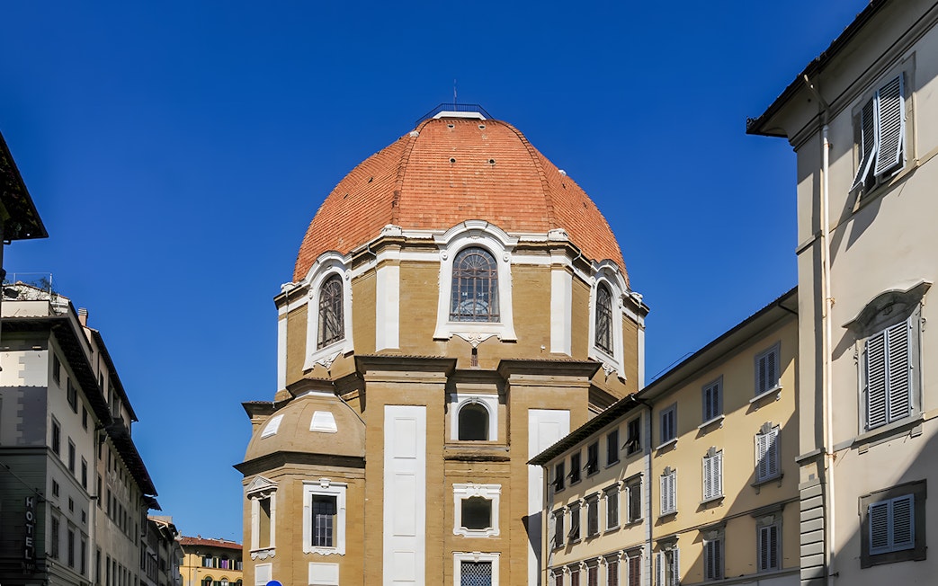 Dome of the Basilica di San Lorenzo in Florence, Italy, framed by nearby buildings.