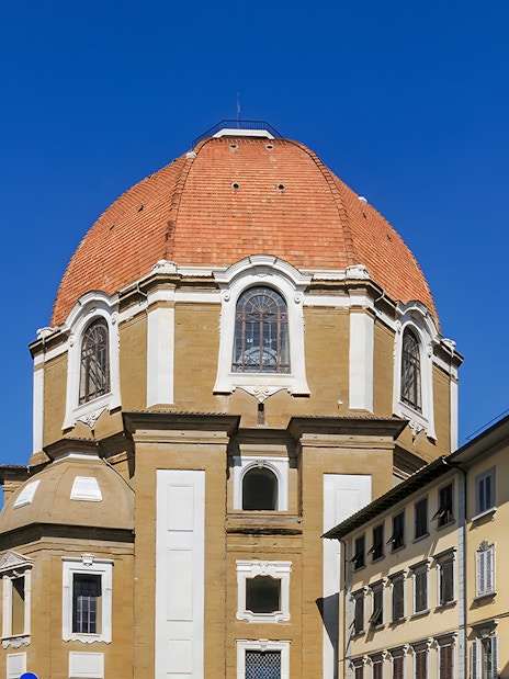 Dome of the Basilica di San Lorenzo in Florence, Italy, framed by nearby buildings.