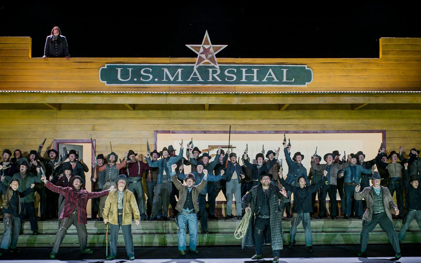 La Fanciulla del West performance at Broadway with actors in front of U.S. Marshal building.