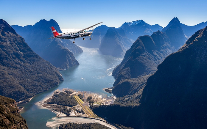 Aerial view of Milford Sound with cruise ship and plane, Queenstown flyover experience.