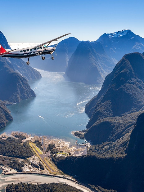Aerial view of Milford Sound with cruise ship and plane, Queenstown flyover experience.
