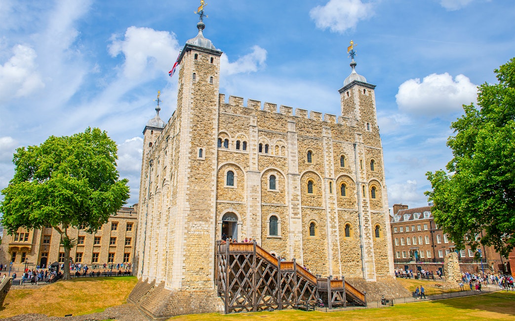 White Tower at the Tower of London with tourists exploring the historic site.