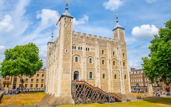 White Tower at the Tower of London with tourists exploring the historic site.