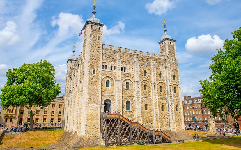 White Tower at the Tower of London with tourists exploring the historic site.