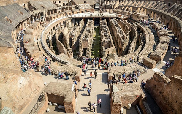 Visitors exploring the first floor of the Colosseum in Rome, Italy.
