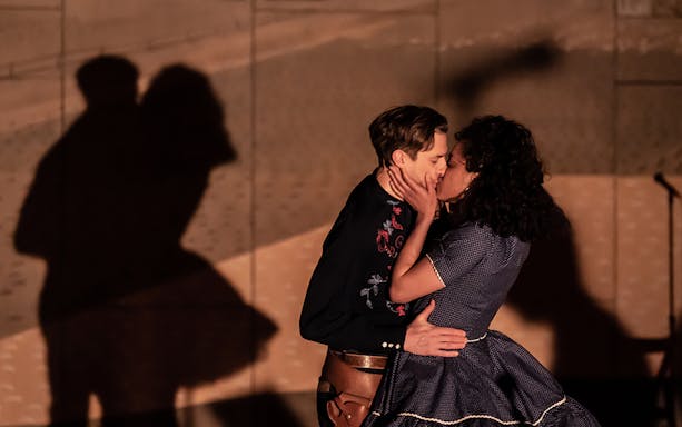 Couple kissing on stage during Oklahoma! performance.