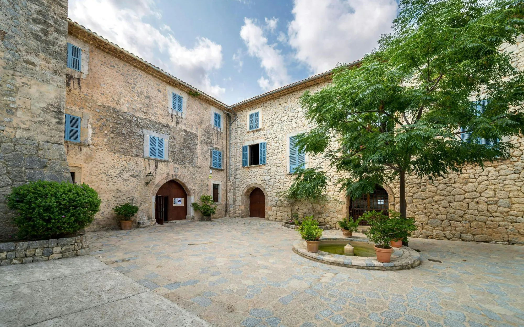 Son Marroig museum courtyard with stone facade and small fountain, Deià, Mallorca.