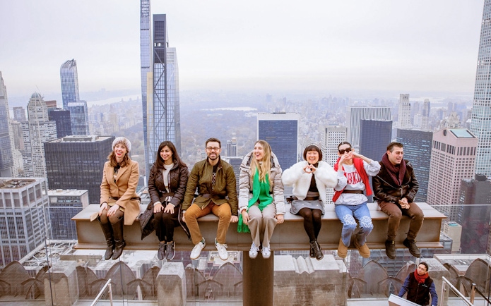 Group enjoying skyline view from Top of the Rock Observation Deck, New York City.