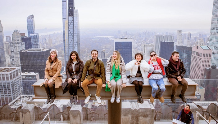 Group enjoying skyline view from Top of the Rock Observation Deck, New York City.