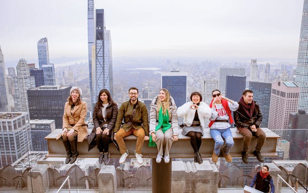 Group enjoying skyline view from Top of the Rock Observation Deck, New York City.