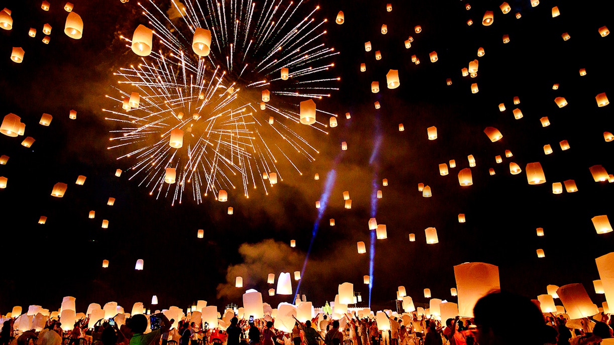 Chiang Mai Sky Lanterns Festival with lanterns and fireworks illuminating the night sky.